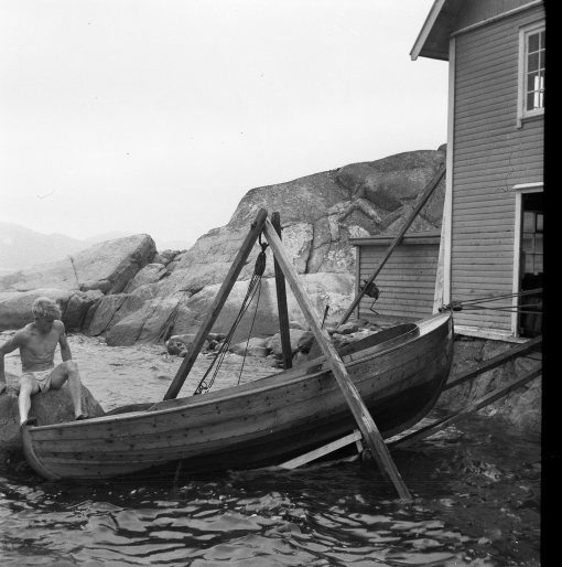 Onkel Einar hjelper til med snekkå inn i naustet. 